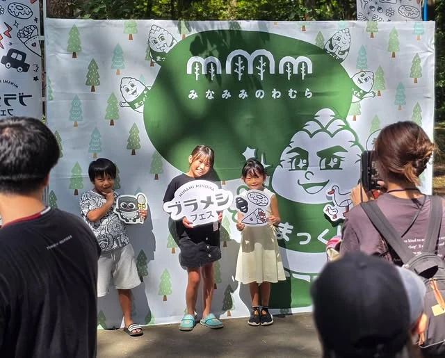 ブラメシフェス2025のフォトブースで手持ちパネルを使う来場者