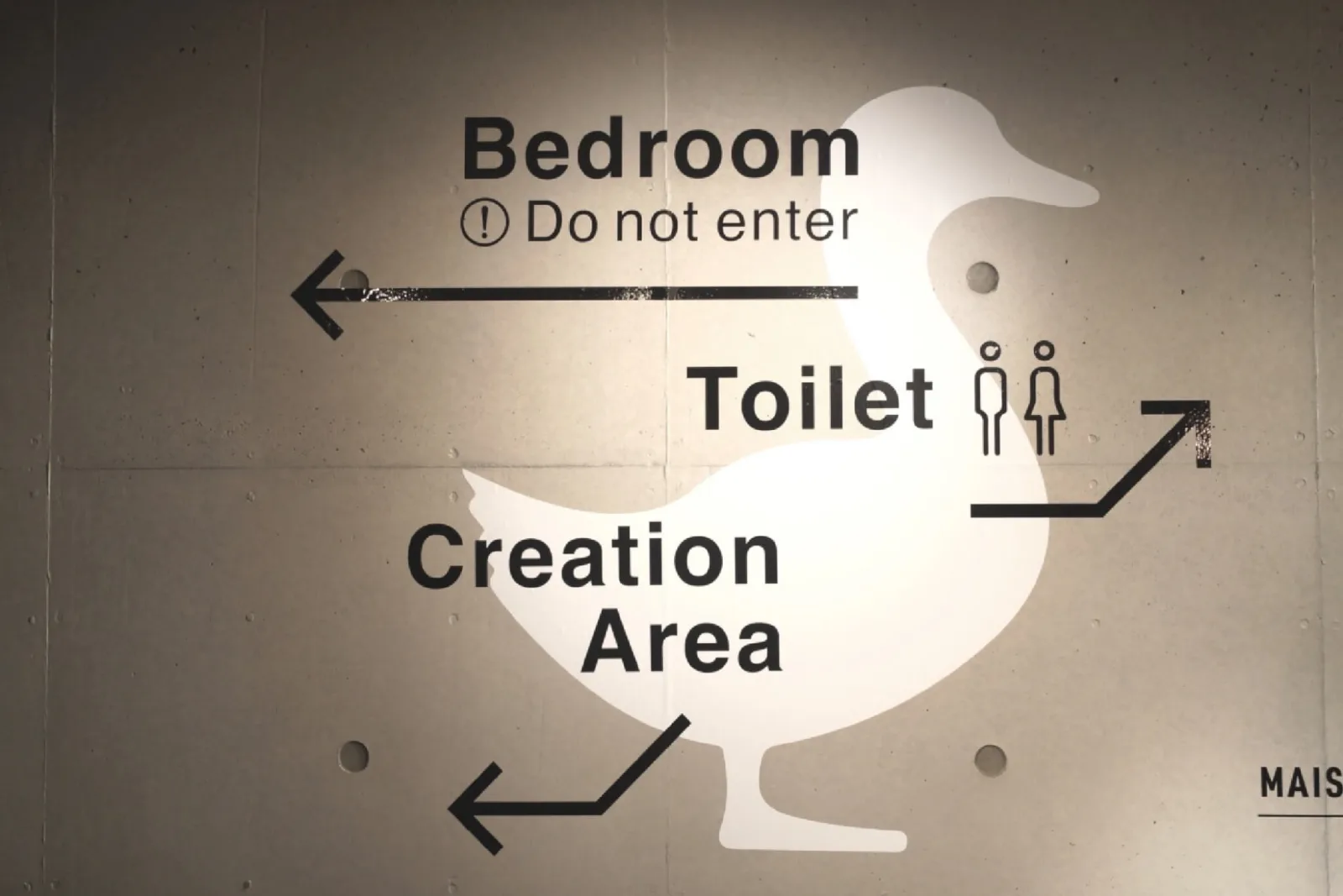 壁面に浮かぶ白いカモのシルエットと「Bedroom」「Toilet」「Creation Area」の案内サイン