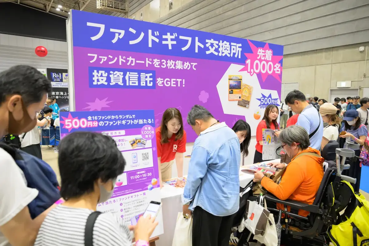 ファンドギフト交換所のブース。案内の看板と、並ぶ来場者